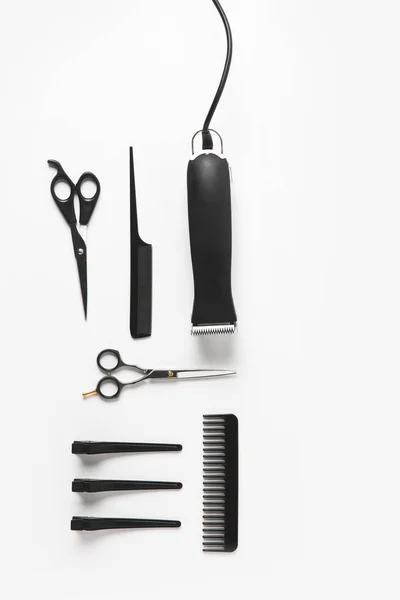 Couche plate avec tondeuse à cheveux et équipement de coiffure, isolé sur blanc — Photo de stock