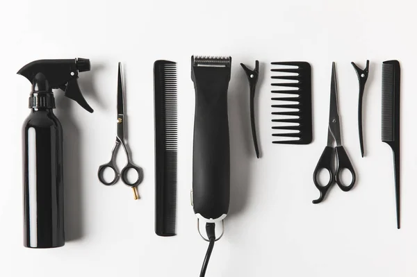 Vista dall'alto di tosatrice per capelli e attrezzatura per parrucchieri in fila, su bianco — Foto stock