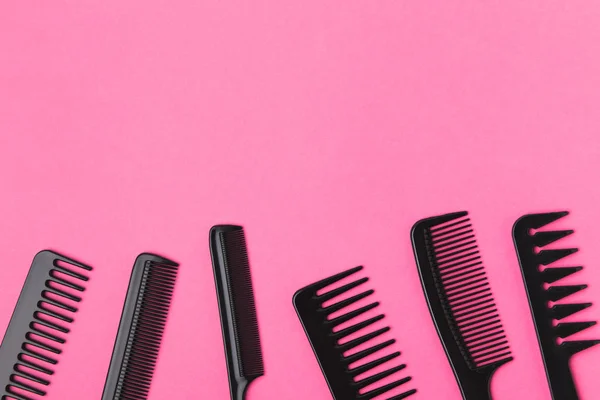 Top view of black combs, isolated on pink — Stock Photo