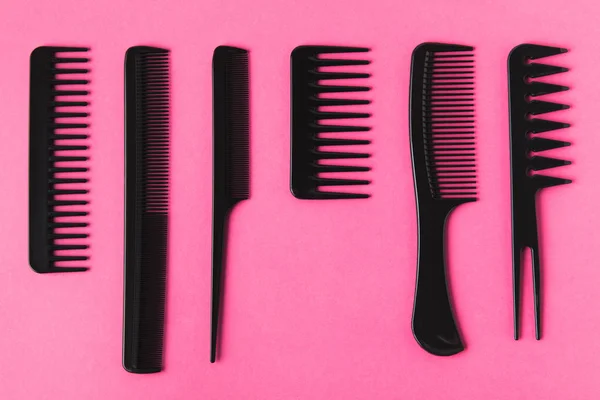 Vista superior de peines de pelo negro, aislado en rosa - foto de stock