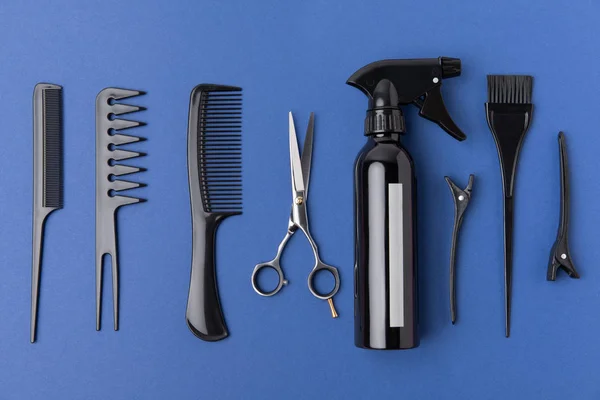 Flat lay com equipamento de cabeleireiro preto, isolado em azul — Fotografia de Stock