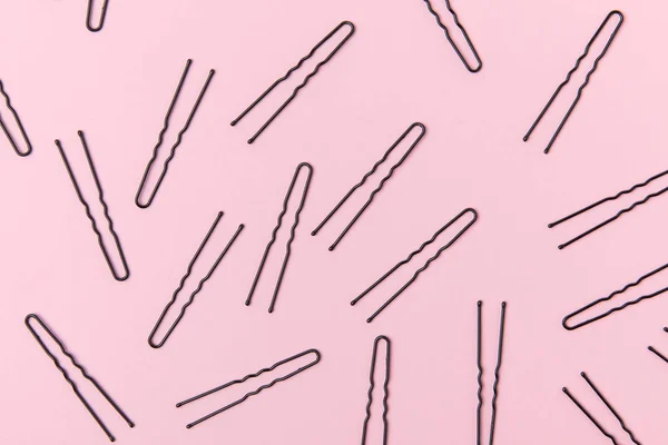 Top view of black hairpins, isolated on light pink — Stock Photo