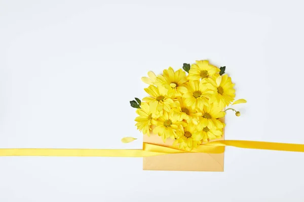 Yellow chrysanthemum flowers in envelope with ribbon isolated on white — Stock Photo