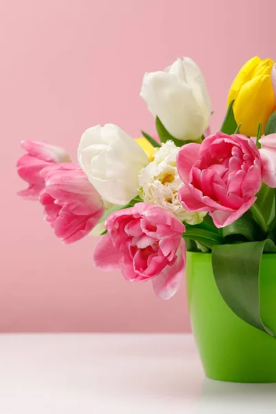 Tender blooming tulips in vase on pink background — Stock Photo