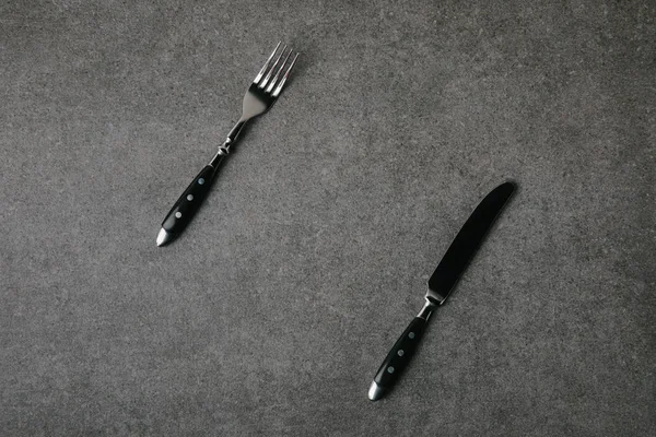 Top view of fork and knife on grey background — Stock Photo