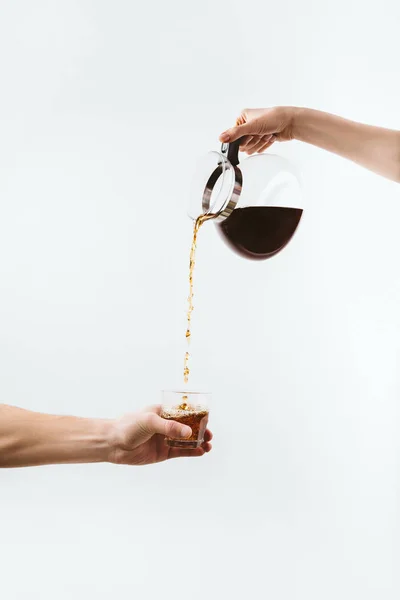 Cropped view of hands with coffee pot and glass, isolated on white — Stock Photo