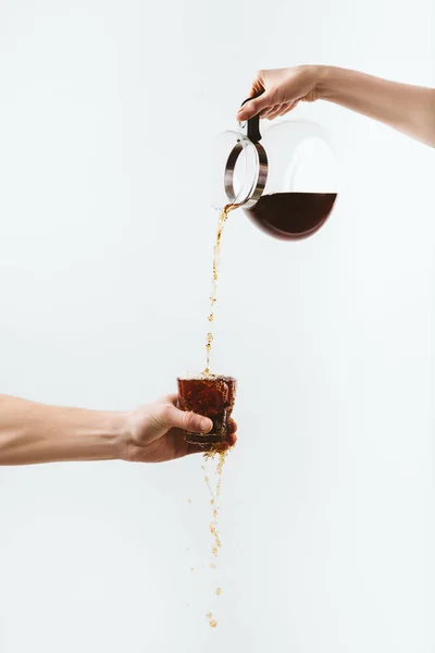 Vista cortada de mãos derramando café de panela em vidro, isolado em branco — Fotografia de Stock