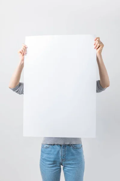 Obscured view of woman with blank banner in hands isolated on white — Stock Photo