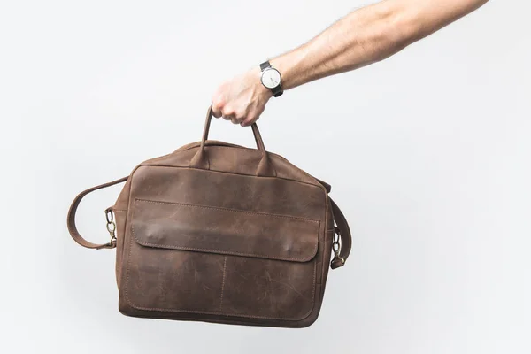 Partial view of man holding leather bag in hand isolated on white — Stock Photo