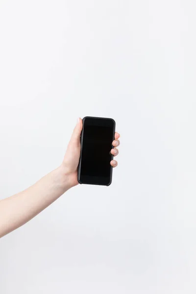 Tiro recortado de mulher segurando smartphone com tela lank isolado no branco — Fotografia de Stock