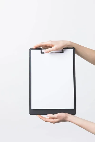 Partial view of woman holding blank clipboard in hands isolated on white — Stock Photo