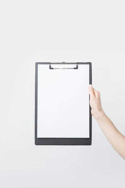 Partial view of woman holding blank clipboard in hand isolated on white — Stock Photo