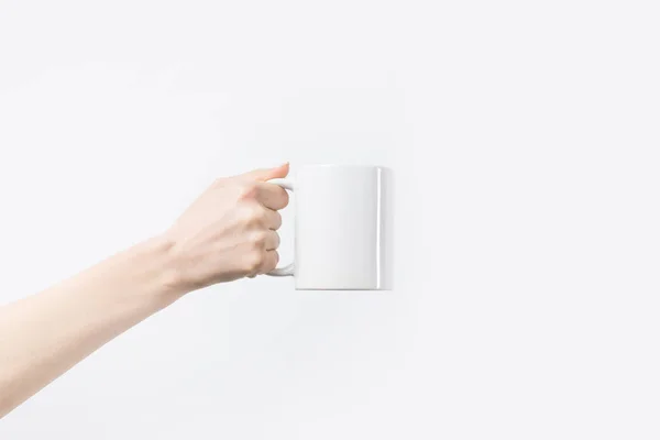 Cropped shot of woman holding white mug in hand isolated on white — Stock Photo