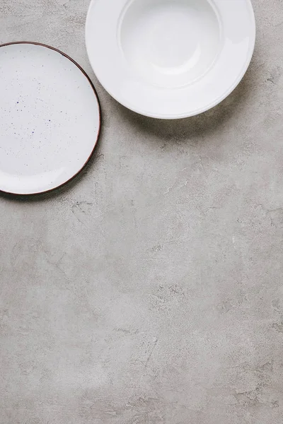 Вид сверху на пустые тарелки на бетонном столе — стоковое фото