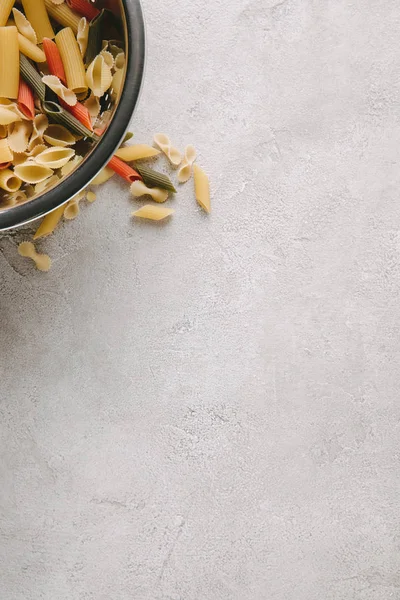 Top view of raw pasta in bowl on concrete tabletop — Stock Photo