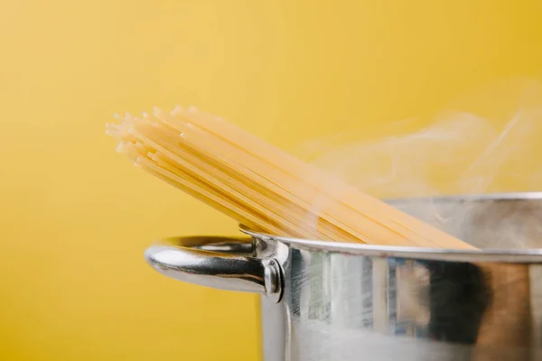 Spaghetti boiling in stewpot isolated on yellow — Stock Photo