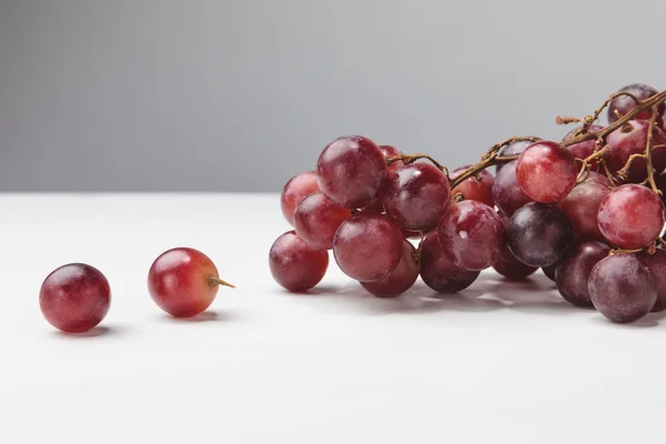 Vue rapprochée de la pile de raisins rouges sur gris — Photo de stock