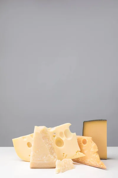 Vista de perto de diferentes tipos de queijo em cinza — Fotografia de Stock