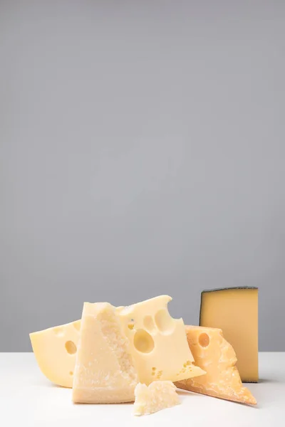 Vue rapprochée de différents types de fromage sur gris — Photo de stock