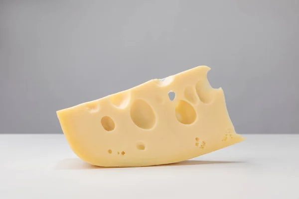 Close up image of maasdam cheese on gray — Stock Photo