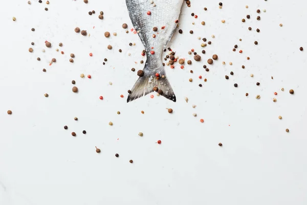 Pesce di mare condito con pepe e sale isolato su bianco — Foto stock