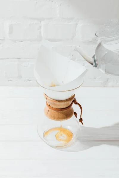 Vista ad alto angolo di versamento di acqua calda dal bollitore in chemex con cono filtro — Foto stock