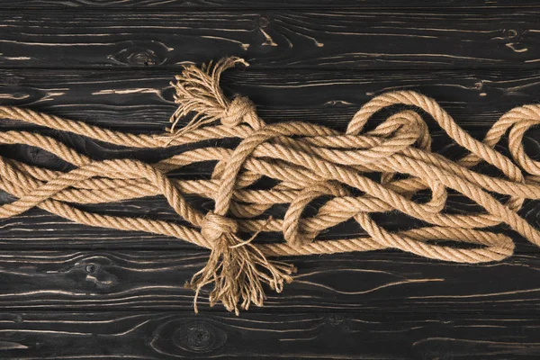 Top view of brown nautical rope on dark wooden planks — Stock Photo