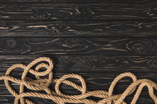Вид зверху на коричневу морську мотузку на темних дерев'яних дошках — стокове фото