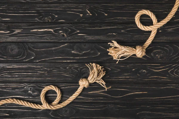 Vista dall'alto di corde nautiche marrone annodate su tavole di legno — Foto stock