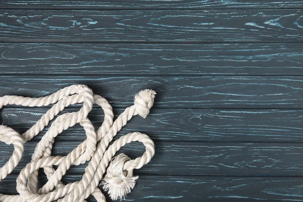 Top view of knotted white nautical rope on wooden planks — Stock Photo