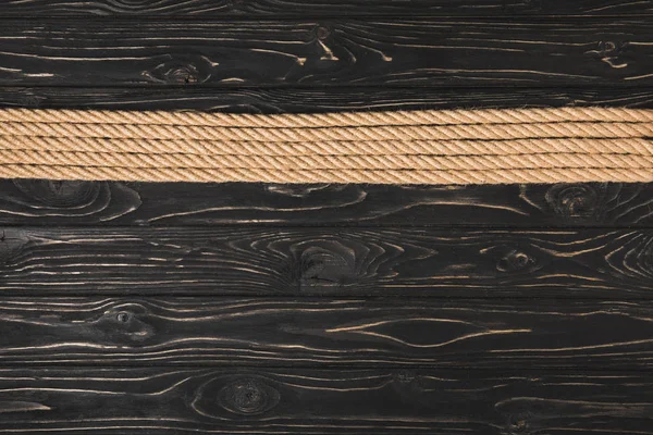 Vue de dessus des cordes nautiques marron placées en rangée sur fond en bois — Photo de stock
