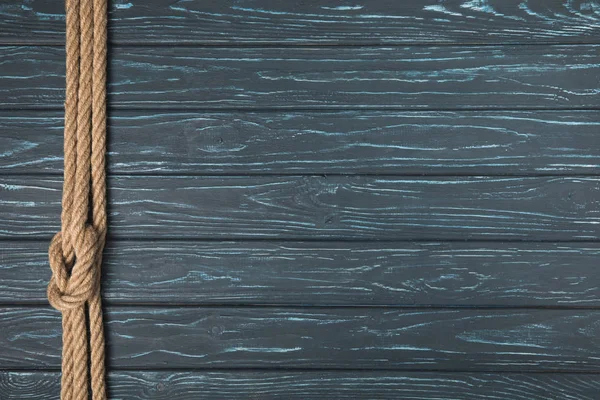 Draufsicht auf Hintergrund mit braunem nautischen Seil mit Knoten auf Holzplanken — Stockfoto