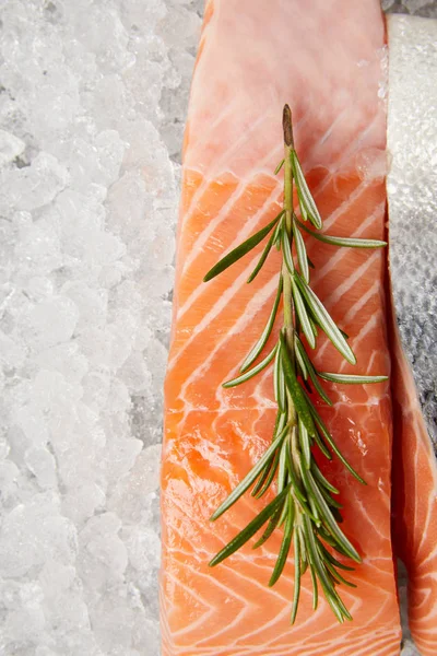 Close-up shot of sliced red fish fillet with rosemary on crushed ice — Stock Photo