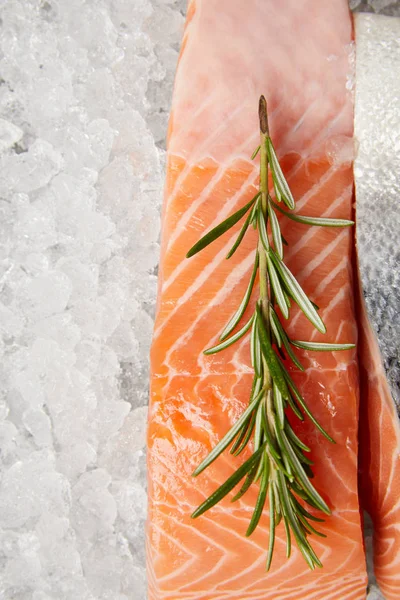 Primer plano de filete de pescado rojo en rodajas con romero sobre hielo picado - foto de stock