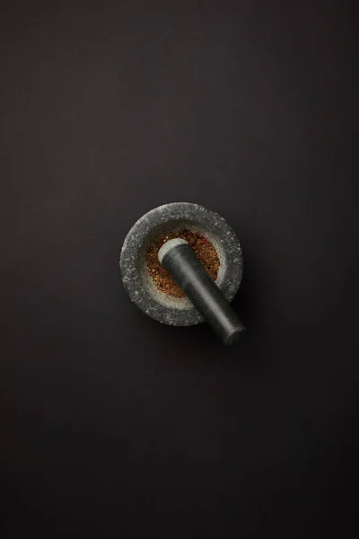 Flat lay with mortar and pestle on black tabletop — Stock Photo