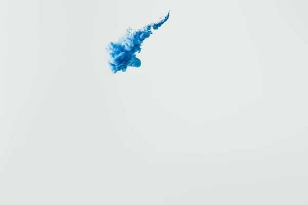 Nahaufnahme von leuchtend blauem Farbspritzer im Wasser isoliert auf grau — Stockfoto