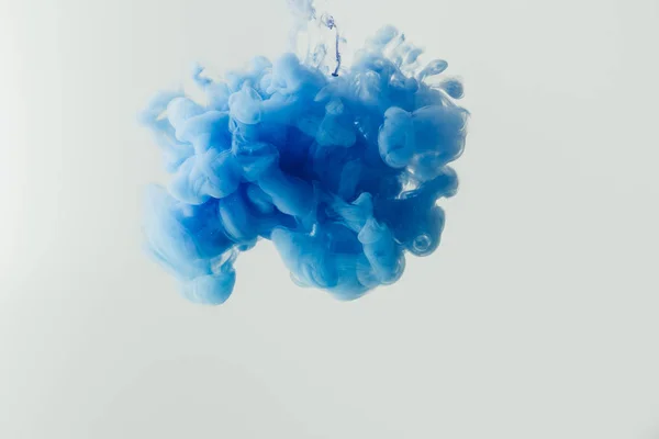 Close-up tiro de respingo de tinta azul brilhante na água isolada em cinza — Stock Photo