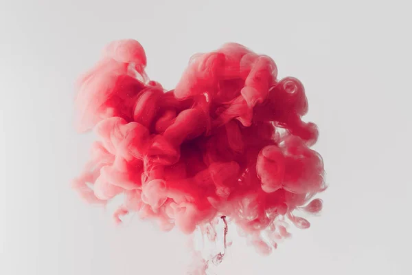 Close up shot of bright red ink  splash in water isolated on gray — Stock Photo