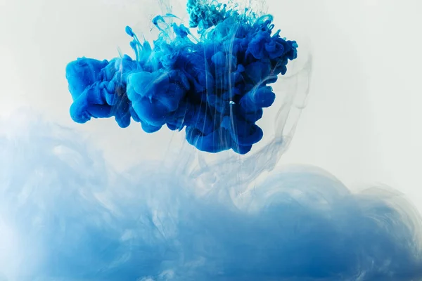 Close up view of mixing of blue and light blue paints splashes  in water isolated on gray — Stock Photo