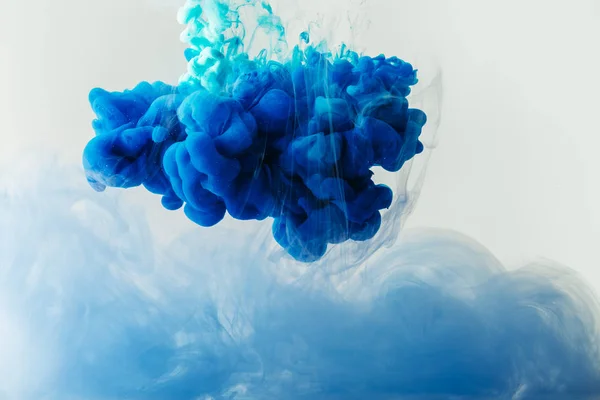 Close up view of mixing of blue and turquoise ink splashes in water isolated on gray — Stock Photo