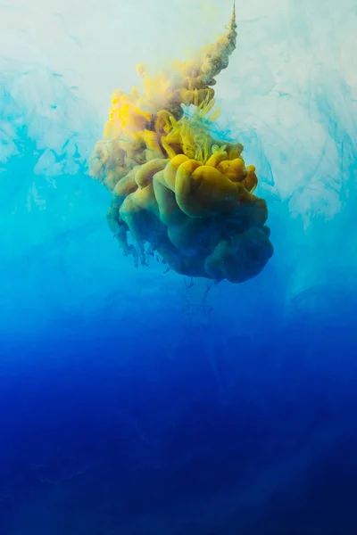Close up view of mixing of blue, turquoise and yellow paints splashes  in water — Stock Photo