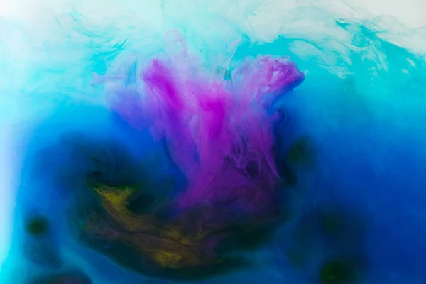 Immagine full frame di miscelazione di blu, turchese, giallo e viola spruzzi di vernici in acqua — Foto stock