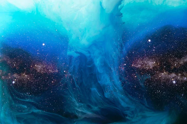 Imagen de marco completo de la mezcla de salpicaduras de pintura azul en el agua con el fondo del universo - foto de stock