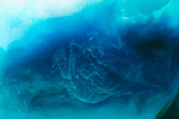 Полная рамка изображения смешивания брызг синих, черных, бирюзовых и белых красок в воде — стоковое фото
