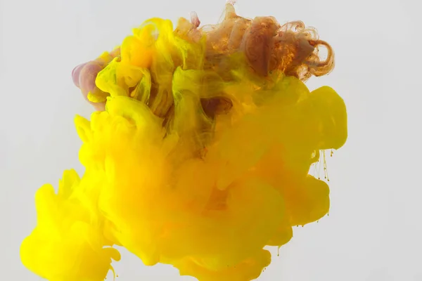 Close-up vista da mistura de tintas amarelo, roxo e marrom salpicos na água isoladas em cinza — Fotografia de Stock
