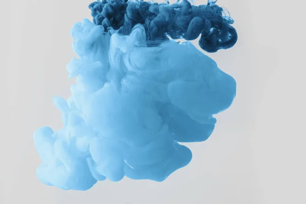 Close up view of mixing of bright pale blue and blue paints splashes  in water isolated on gray — Stock Photo