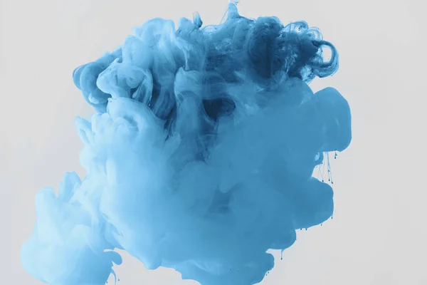 Close up view of mixing of bright pale blue and blue ink splashes in water isolated on gray — Stock Photo