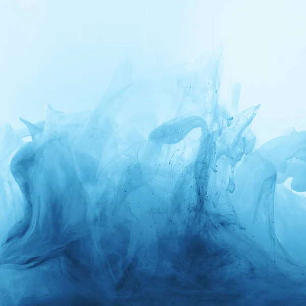 Imagen de marco completo de mezcla de salpicaduras de tinta azul pálido brillante y azul en el agua — Stock Photo