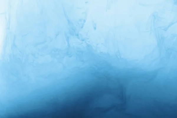 Imagen de marco completo de la mezcla de brillantes pinturas azul pálido y azul salpicaduras en el agua - foto de stock