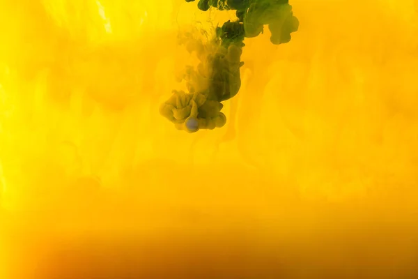 Full frame image of mixing of yellow and green paints splashes  in water — Stock Photo